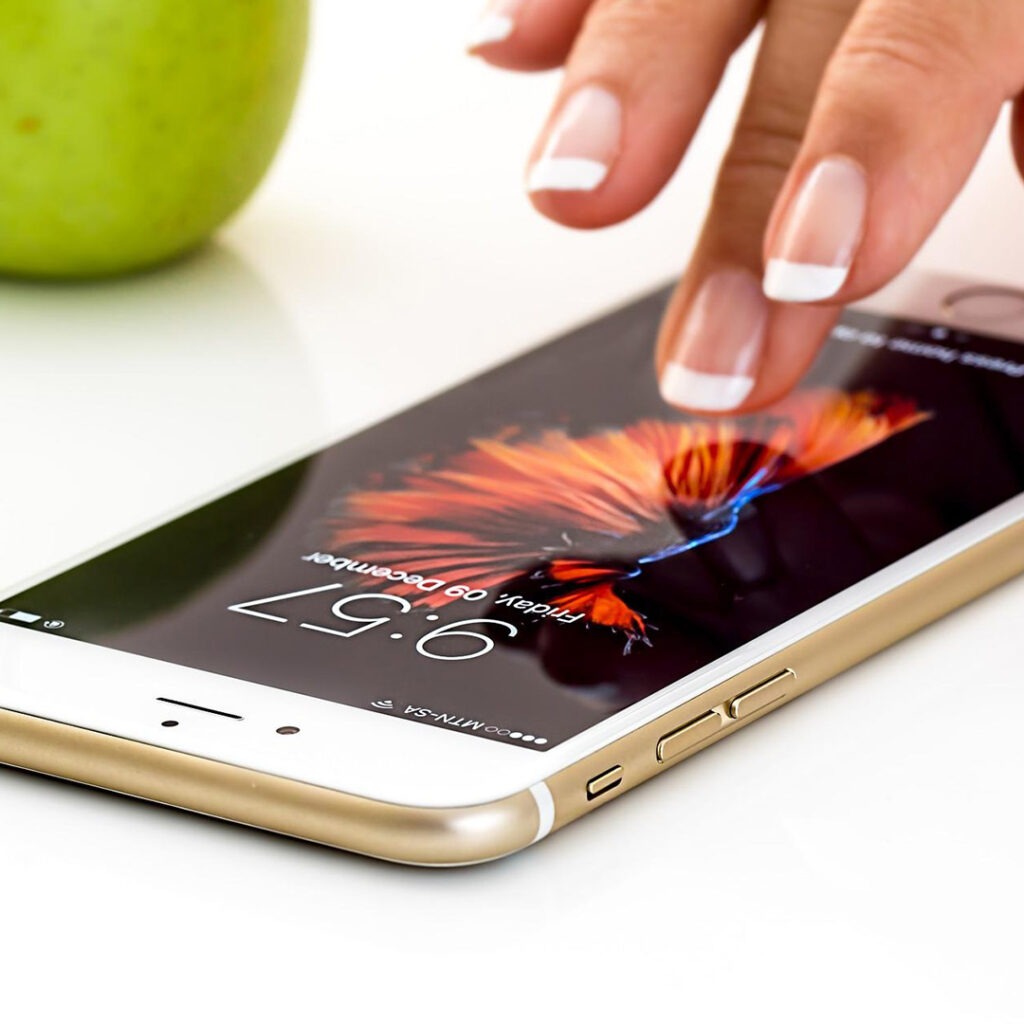 A manicured woman's hand scrolling on her phone. 